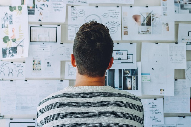 A man analyzing his digital marketing strategies on a wall, planning online business growth and marketing campaigns.